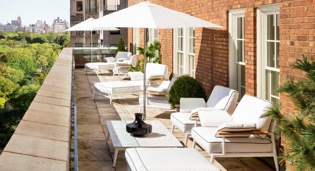 Slideshow 1 A patio with white furniture and an umbrella.